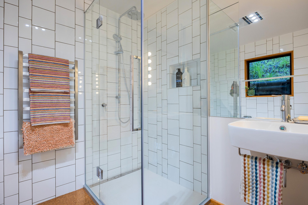 Inspiration for a mid-sized eclectic bathroom in Auckland with a corner tub, a corner shower, white tile, ceramic tile, white walls, cork floors, a wall-mount sink, brown floor, a hinged shower door, a single vanity and a floating vanity.