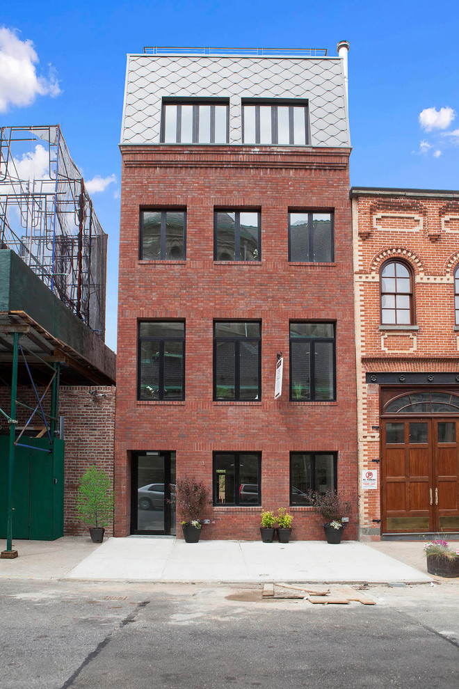 Photo of a large modern three-storey brick red townhouse exterior in New York with a hip roof.