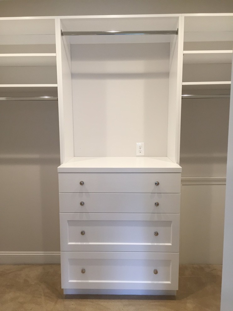Inspiration for a mid-sized transitional gender-neutral walk-in wardrobe in Raleigh with recessed-panel cabinets, white cabinets and carpet.