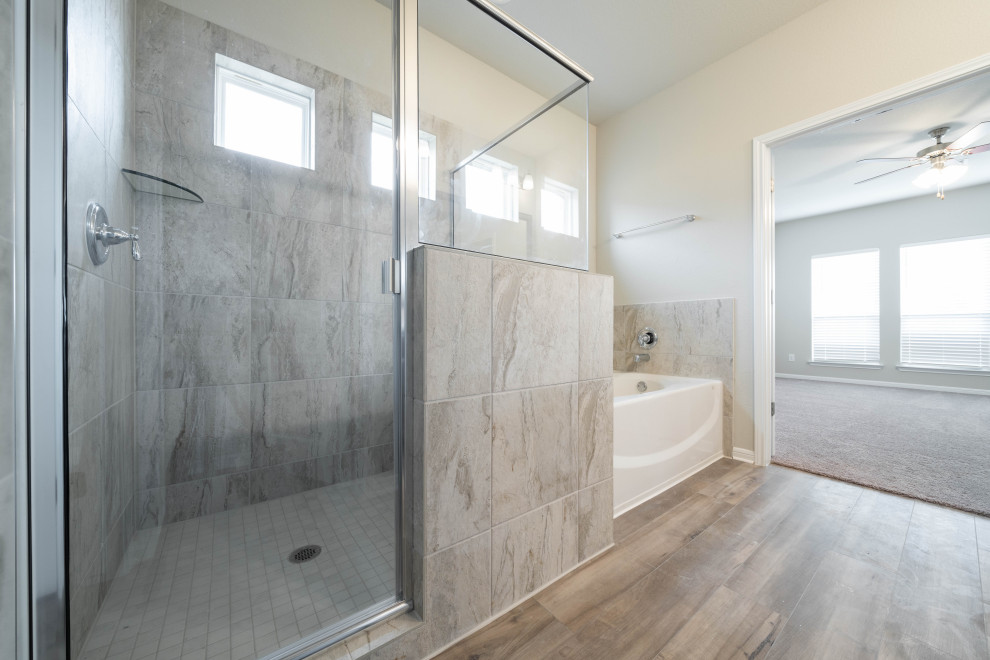This is an example of a large arts and crafts master bathroom in Austin with shaker cabinets, dark wood cabinets, an alcove tub, a corner shower, a one-piece toilet, beige tile, ceramic tile, grey walls, vinyl floors, an undermount sink, granite benchtops, beige floor, a hinged shower door, beige benchtops, an enclosed toilet, a double vanity and a built-in vanity.