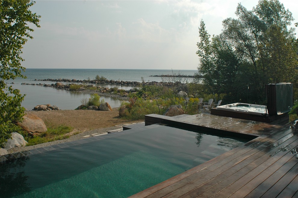 Design ideas for a large contemporary backyard rectangular lap pool in Toronto with decking.