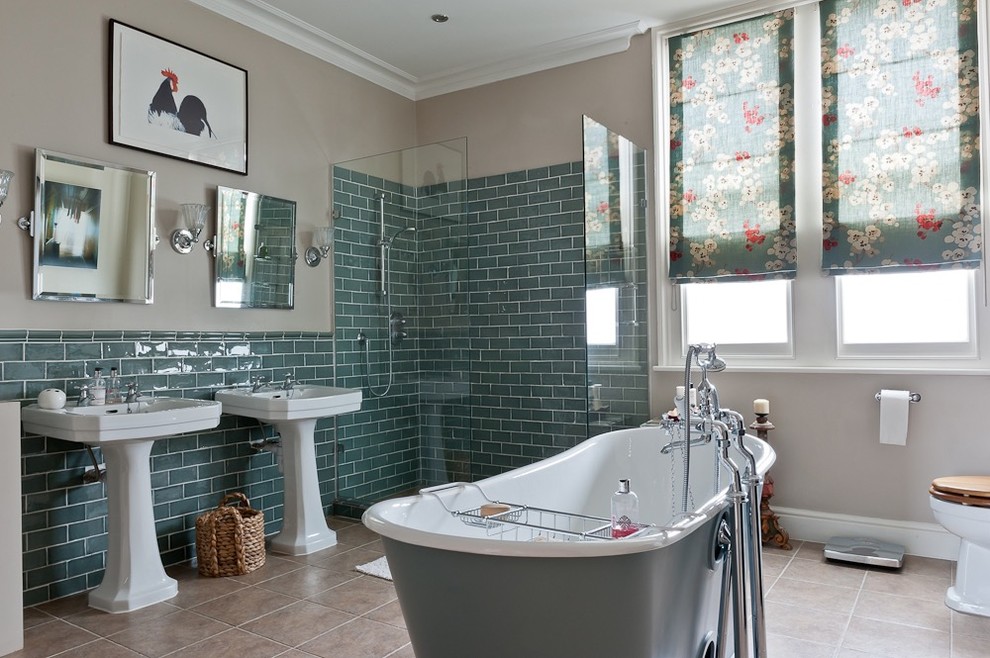 Inspiration for a mid-sized traditional master bathroom in London with a freestanding tub, a one-piece toilet, blue tile, ceramic tile, brown walls, ceramic floors and brown floor.