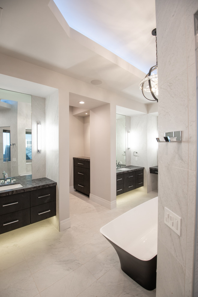Bathroom - large modern master white tile and slate tile slate floor, white floor, double-sink and tray ceiling bathroom idea in Phoenix with flat-panel cabinets, black cabinets, a one-piece toilet, white walls, a drop-in sink, granite countertops, multicolored countertops and a floating vanity