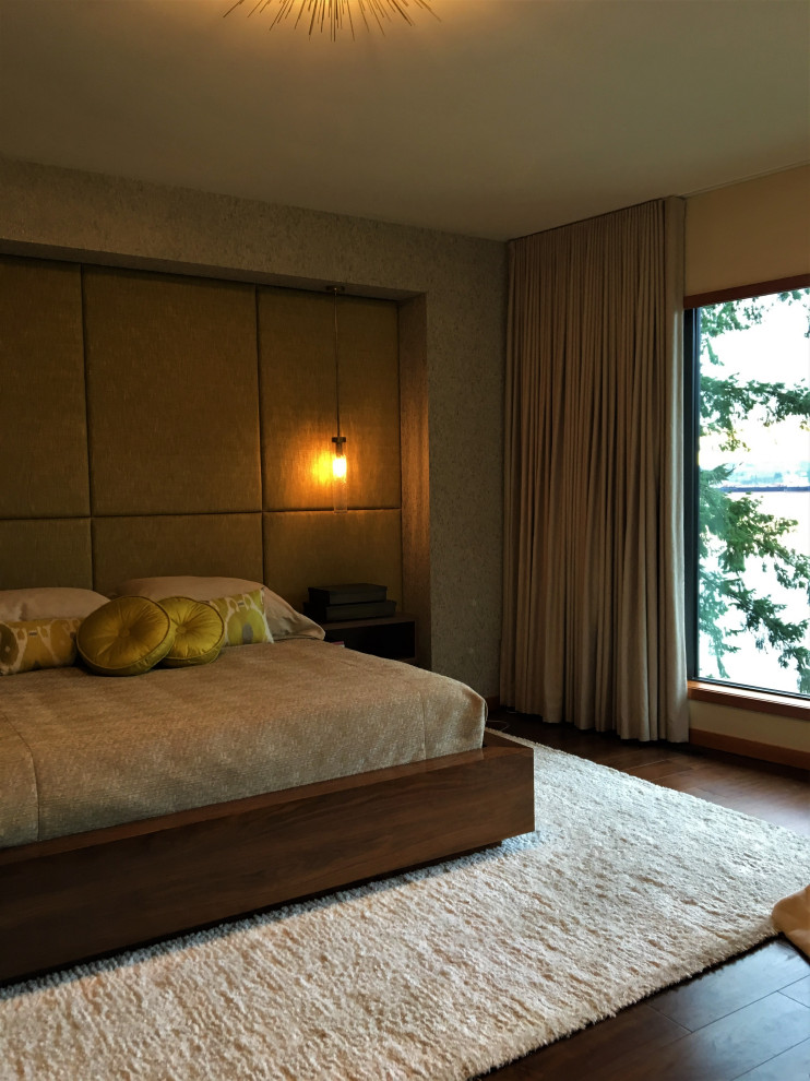 Design ideas for a midcentury master bedroom in Vancouver with green walls, medium hardwood floors, a standard fireplace, a stone fireplace surround, brown floor, coffered and wallpaper.