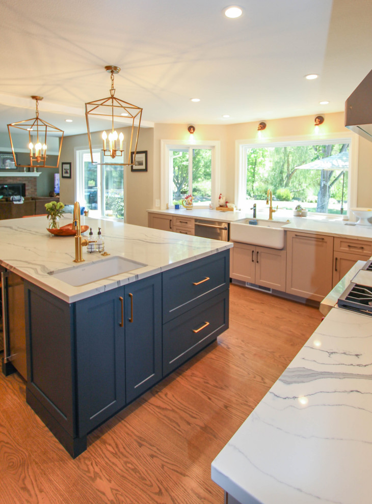 Inspiration for a large transitional u-shaped kitchen in San Francisco with a farmhouse sink, recessed-panel cabinets, beige cabinets, quartz benchtops, white splashback, stone slab splashback, stainless steel appliances, medium hardwood floors, with island, brown floor and white benchtop.