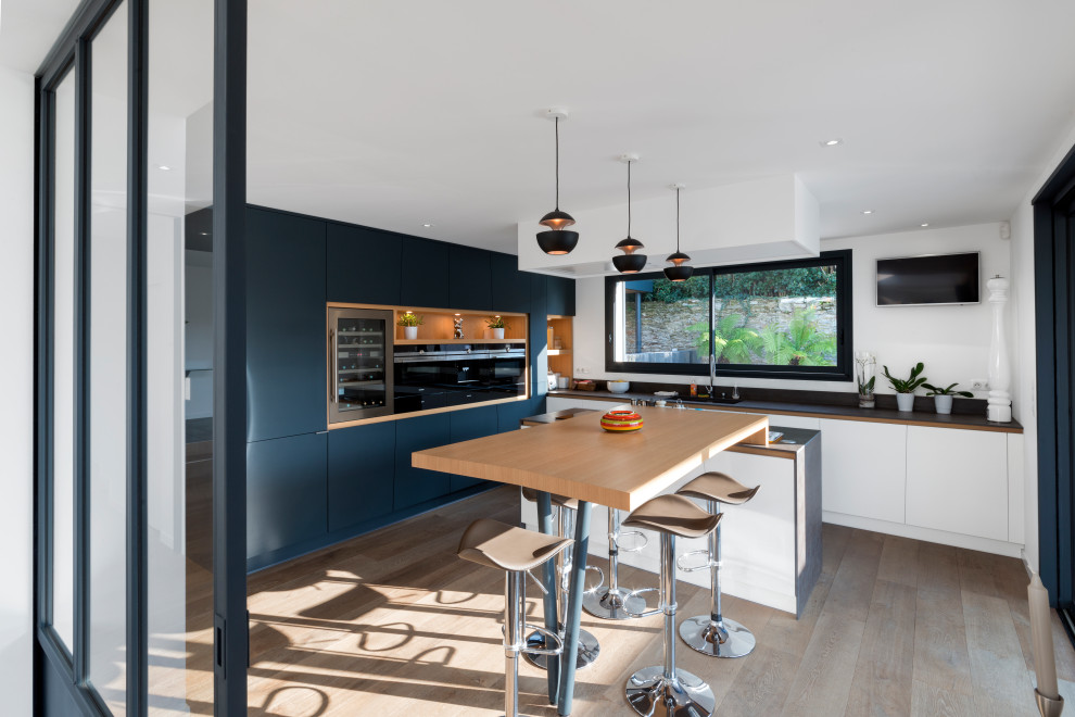This is an example of a large contemporary l-shaped eat-in kitchen in Nantes with black cabinets and with island.