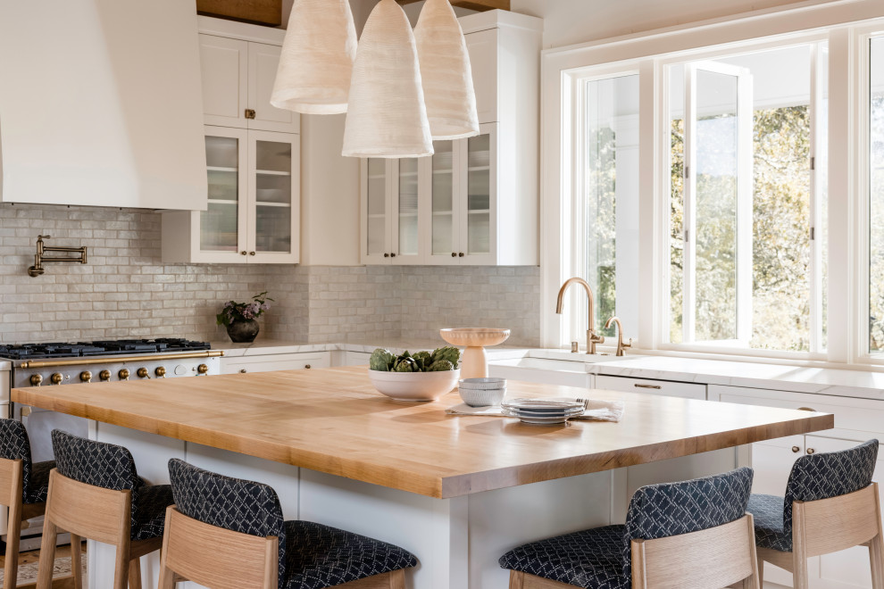 Photo of a farmhouse kitchen/diner in San Francisco with a belfast sink and an island.