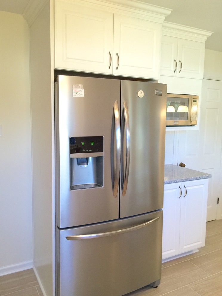 Inspiration for a mid-sized u-shaped porcelain tile enclosed kitchen remodel with a peninsula, raised-panel cabinets, white cabinets, granite countertops, white backsplash, subway tile backsplash, stainless steel appliances and an undermount sink