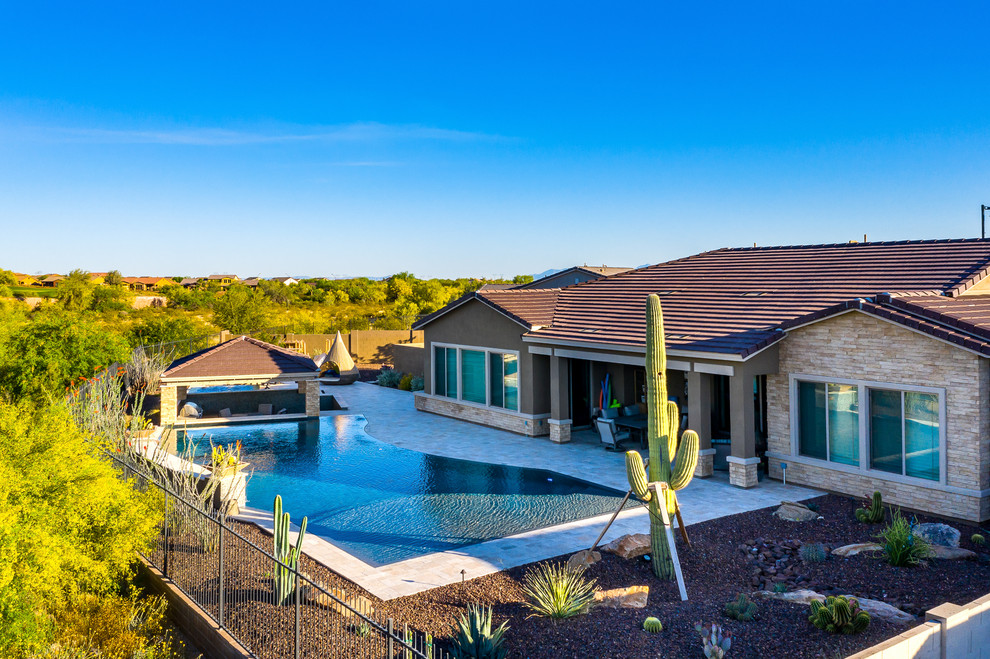 Hot tub - large backyard stone and custom-shaped hot tub idea in Phoenix
