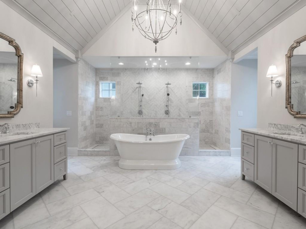 Inspiration for an expansive transitional master bathroom in Atlanta with shaker cabinets, grey cabinets, a freestanding tub, an open shower, white tile, marble, an undermount sink, marble benchtops, white floor, white benchtops, an enclosed toilet, a freestanding vanity and vaulted.