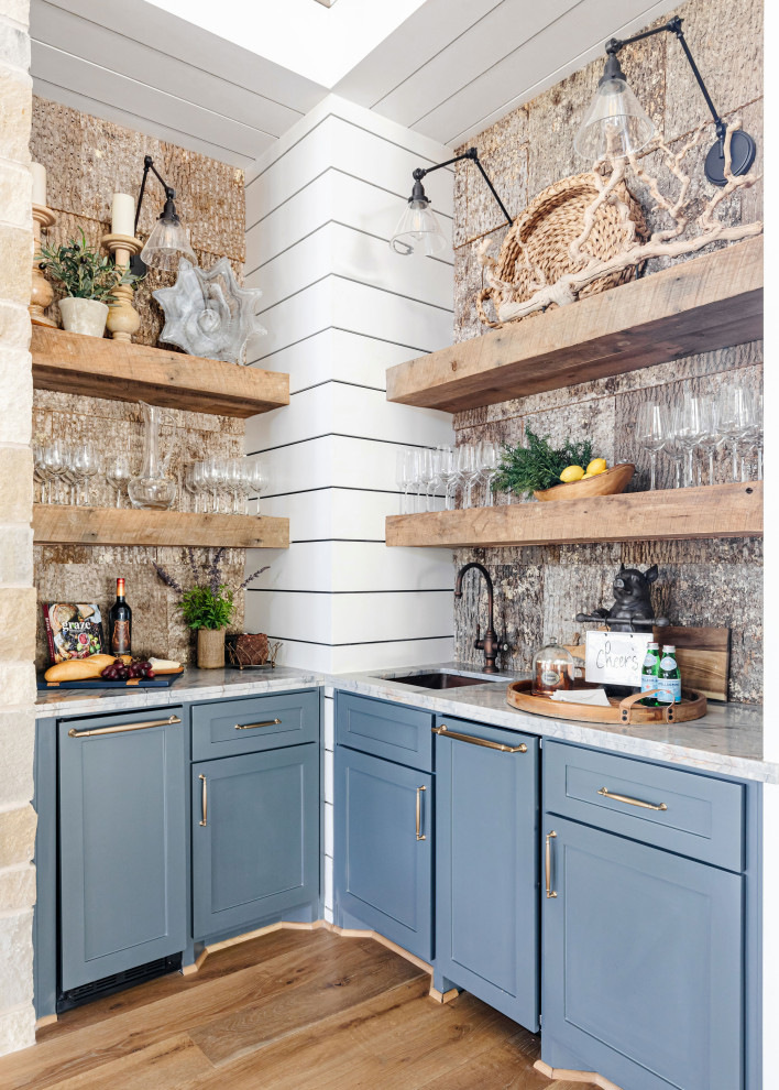Inredning av en rustik flerfärgade l-formad flerfärgat hemmabar med vask, med en undermonterad diskho, skåp i shakerstil, blå skåp, marmorbänkskiva, flerfärgad stänkskydd, mellanmörkt trägolv och brunt golv