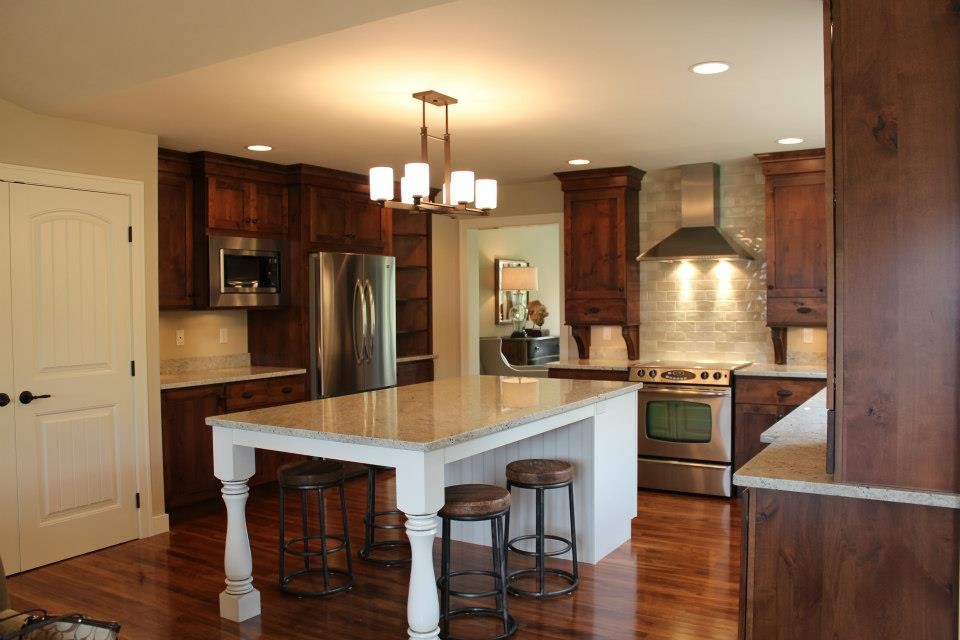 Inspiration for a large arts and crafts u-shaped open plan kitchen in Cedar Rapids with an undermount sink, shaker cabinets, dark wood cabinets, beige splashback, stainless steel appliances, dark hardwood floors, with island, terrazzo benchtops, ceramic splashback and brown floor.