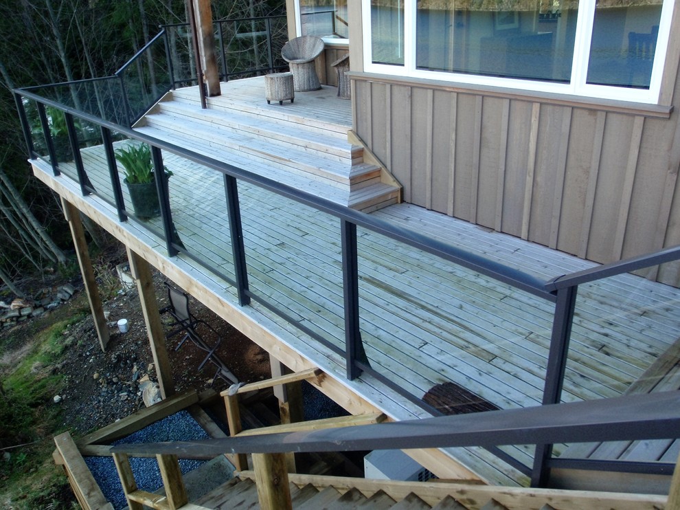 Large arts and crafts backyard deck in Vancouver with with dock and no cover.