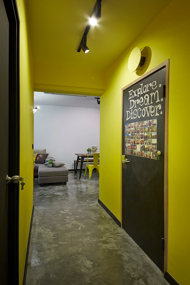 Small eclectic hallway in Singapore with yellow walls and concrete floors.
