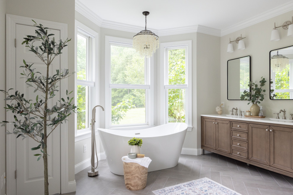 Photo of a large transitional master bathroom in Philadelphia with shaker cabinets, light wood cabinets, a freestanding tub, an open shower, a one-piece toilet, grey walls, porcelain floors, an integrated sink, engineered quartz benchtops, grey floor, a hinged shower door, white benchtops, a shower seat, a double vanity and a freestanding vanity.