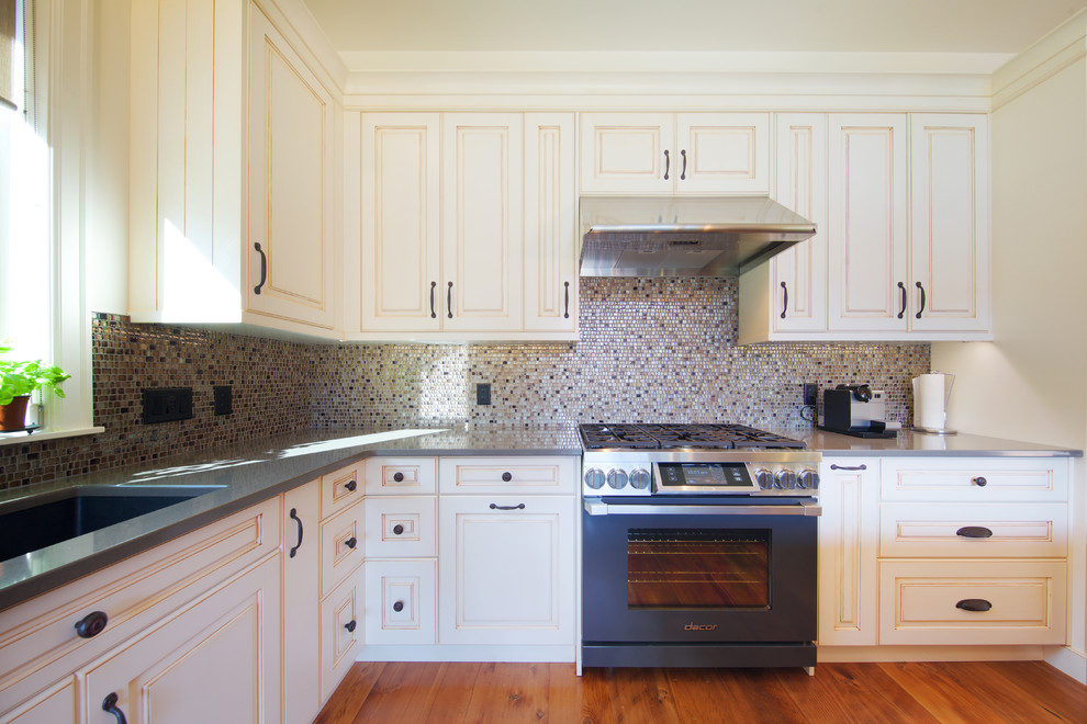 Example of a mid-sized mountain style galley medium tone wood floor open concept kitchen design in Vancouver with an undermount sink, louvered cabinets, white cabinets, multicolored backsplash, ceramic backsplash, stainless steel appliances and an island