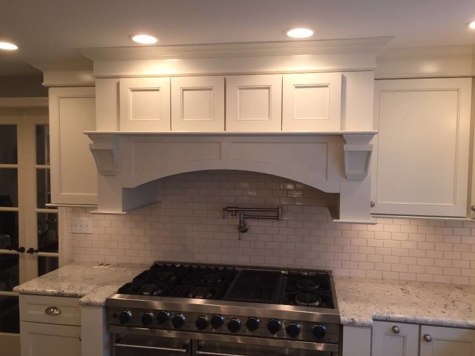 Kitchen - transitional u-shaped dark wood floor kitchen idea in New York with an undermount sink, recessed-panel cabinets, white cabinets, granite countertops, white backsplash, subway tile backsplash, stainless steel appliances and an island