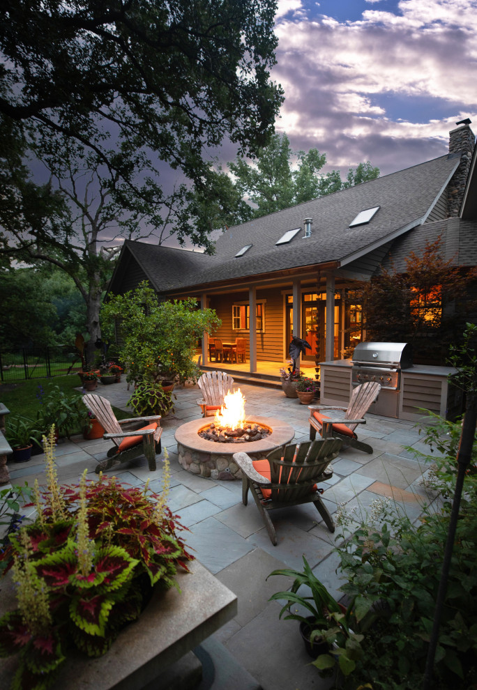 Пример оригинального дизайна: большой двор на заднем дворе в стиле кантри с местом для костра, покрытием из каменной брусчатки и навесом