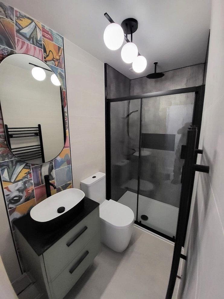 Inspiration for a medium sized modern family bathroom in Other with flat-panel cabinets, green cabinets, an alcove shower, a two-piece toilet, grey tiles, porcelain tiles, laminate floors, a vessel sink, terrazzo worktops, grey floors, a sliding door, black worktops, a single sink and a floating vanity unit.