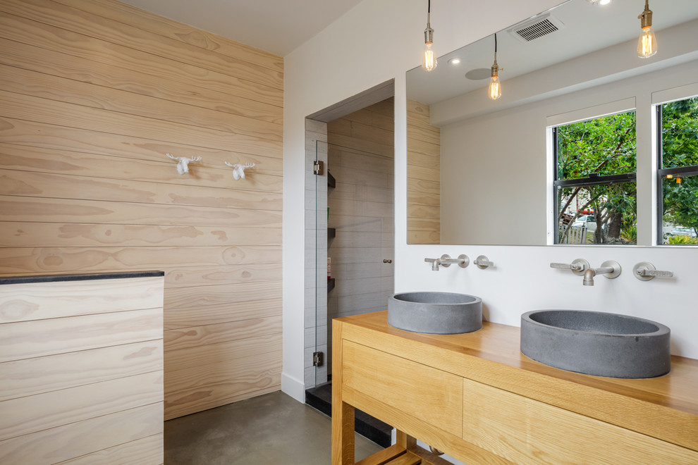 This is an example of a mid-sized scandinavian master bathroom in San Francisco with flat-panel cabinets, light wood cabinets, beige tile, concrete floors, a vessel sink, wood benchtops, grey floor, a hinged shower door, beige benchtops and white walls.