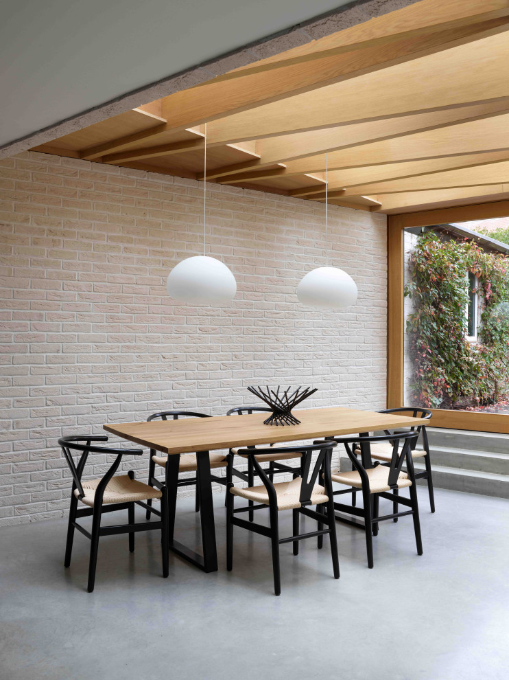 Exempel på en mellanstor minimalistisk matplats med öppen planlösning, med betonggolv och grått golv
