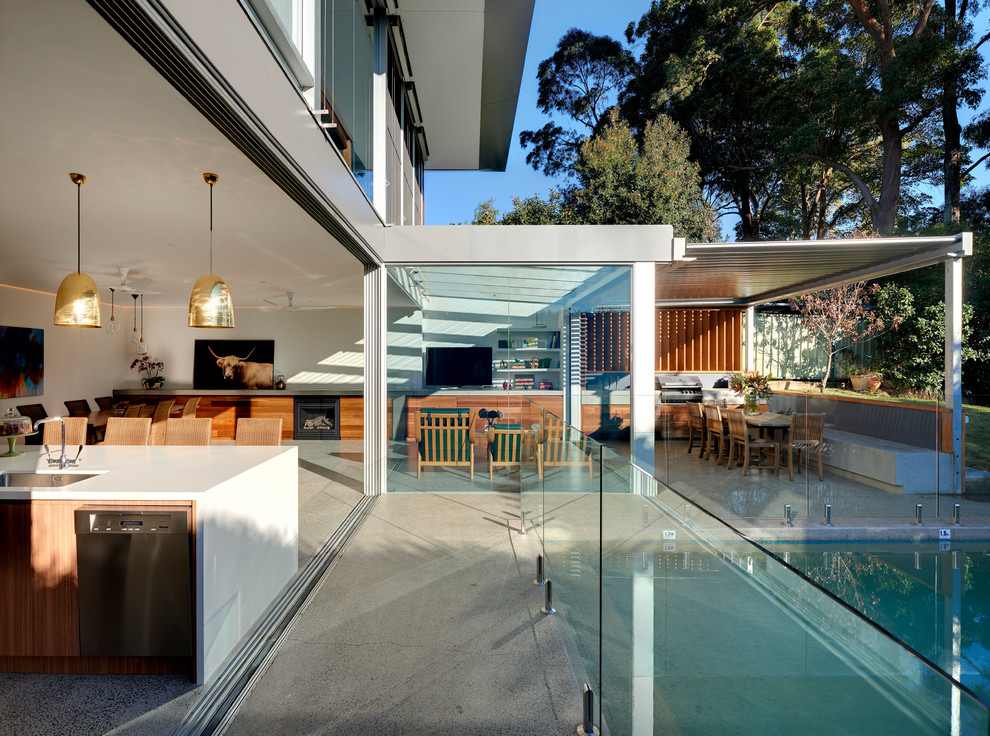 Inspiration for a mid-sized contemporary backyard rectangular lap pool in Sydney with concrete slab and a water feature.