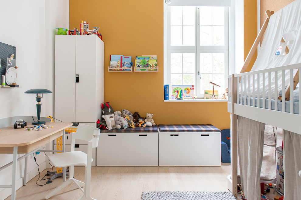 Design ideas for a contemporary kids' room for kids 4-10 years old in Berlin with multi-coloured walls and light hardwood floors.