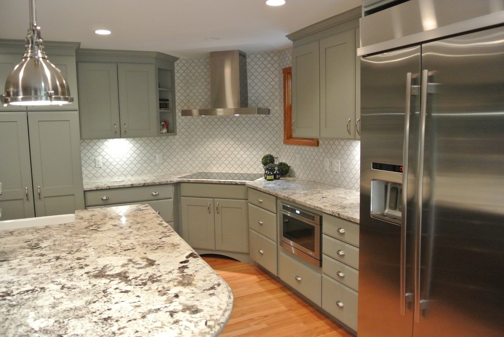 Example of a large transitional l-shaped light wood floor eat-in kitchen design in Boston with a farmhouse sink, shaker cabinets, gray cabinets, granite countertops, white backsplash, ceramic backsplash, stainless steel appliances, an island and gray countertops