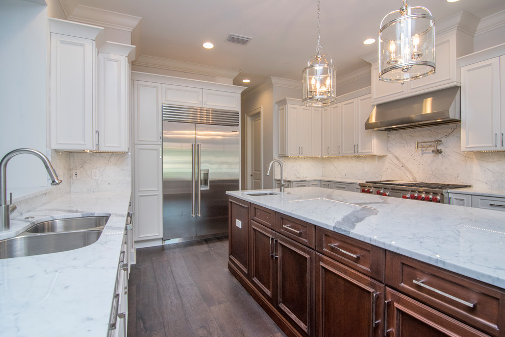 Inspiration for a large transitional u-shaped dark wood floor and brown floor enclosed kitchen remodel in Tampa with an undermount sink, recessed-panel cabinets, white cabinets, marble countertops, gray backsplash, marble backsplash, stainless steel appliances and an island