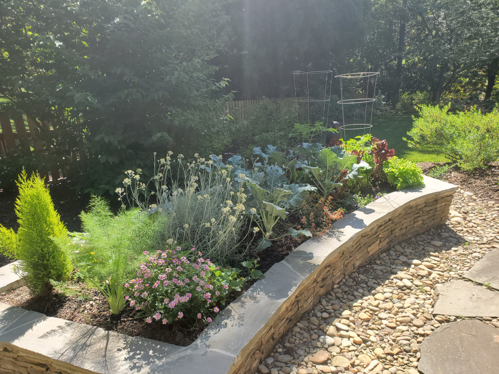 This is an example of a large traditional backyard full sun xeriscape in Other with with raised garden bed and natural stone pavers.