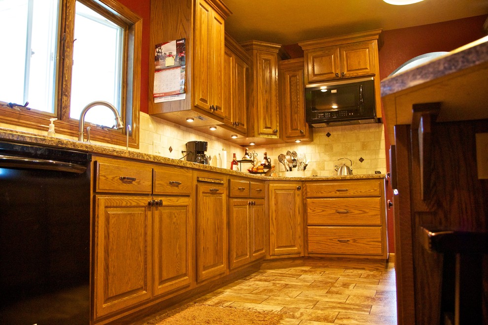 Open concept kitchen - mid-sized l-shaped linoleum floor open concept kitchen idea with an undermount sink, raised-panel cabinets, medium tone wood cabinets, laminate countertops, beige backsplash, stone tile backsplash, black appliances and an island