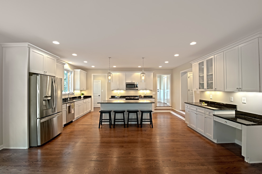 Inspiration for a transitional medium tone wood floor kitchen remodel in Richmond with shaker cabinets, white cabinets, granite countertops, stainless steel appliances and an island