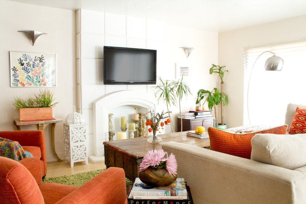 Eclectic living room in Los Angeles with white walls, a standard fireplace and a wall-mounted tv.