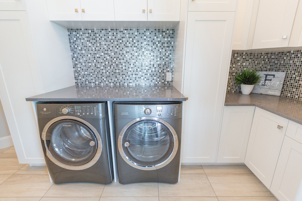 Laundry room - transitional beige floor laundry room idea with shaker cabinets, white cabinets, quartz countertops, beige walls, a side-by-side washer/dryer and gray countertops