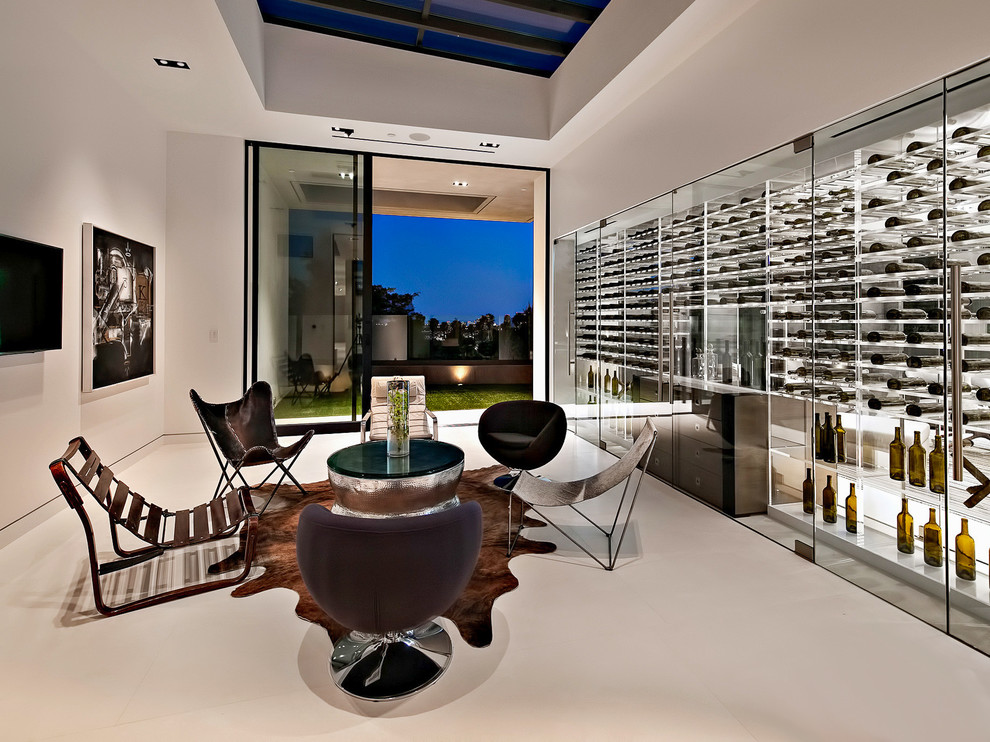 This is an example of a mid-sized contemporary wine cellar in Los Angeles with concrete floors, storage racks and white floor.