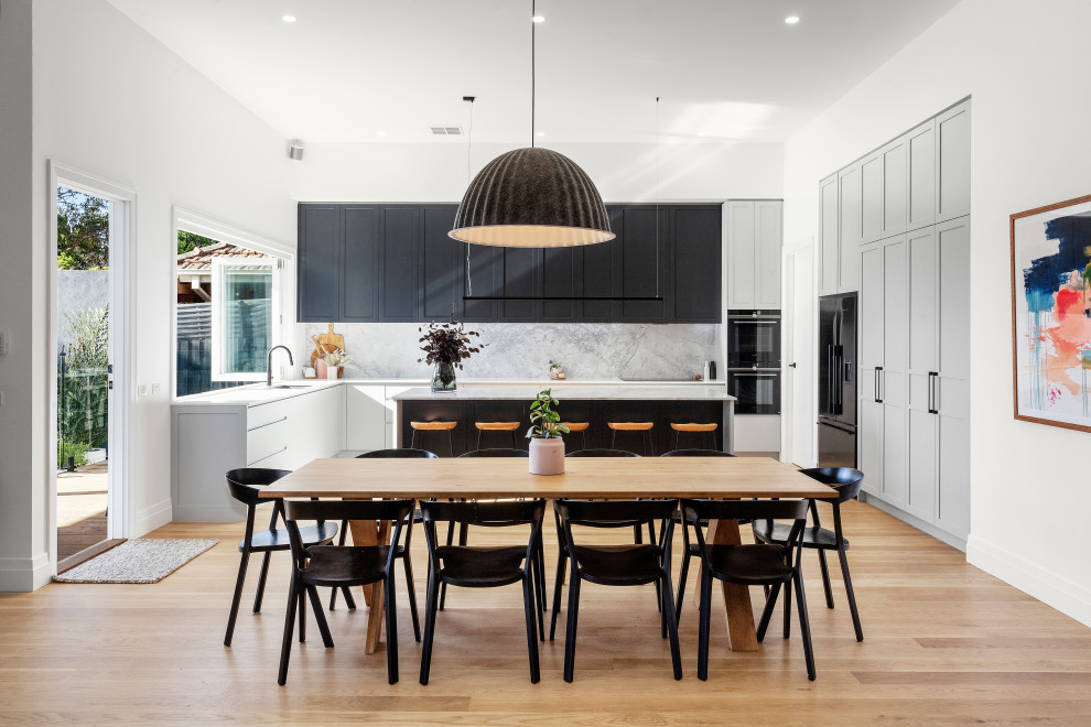 Large contemporary open plan dining in Melbourne with light hardwood floors.