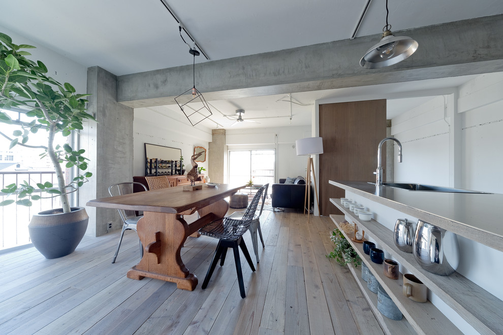 Large industrial open plan dining in Kobe with white walls, light hardwood floors and beige floor.