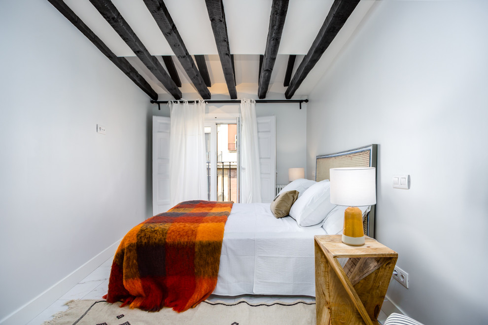 This is an example of a mediterranean guest bedroom in Madrid with white walls and white floor.