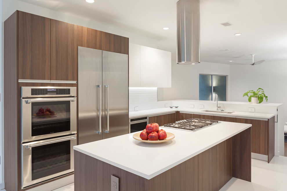 Photo of a contemporary kitchen in Houston with an undermount sink, flat-panel cabinets, medium wood cabinets, quartz benchtops, white splashback, porcelain splashback, stainless steel appliances, porcelain floors and with island.