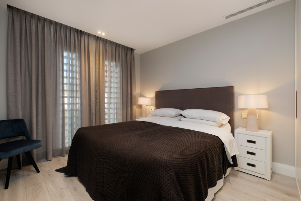 Modelo de dormitorio principal contemporáneo sin chimenea con paredes grises y suelo gris