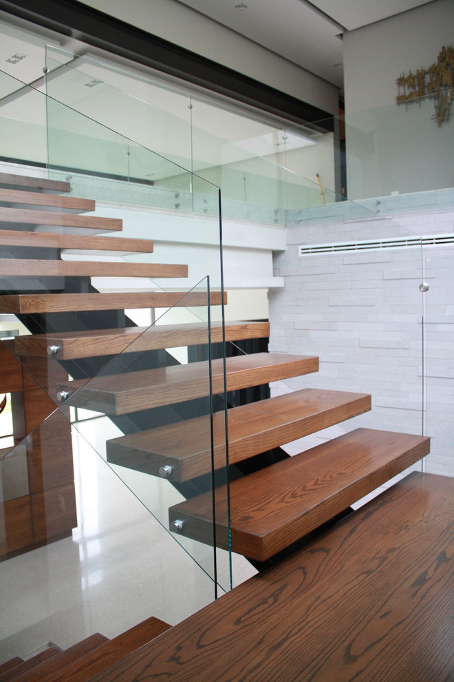 Inspiration for a contemporary glass u-shaped staircase with metal risers.
