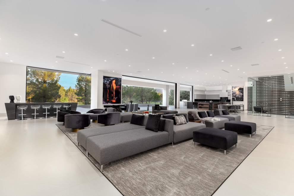 Inspiration for an expansive modern open concept family room in Las Vegas with a library, white walls, a ribbon fireplace and a built-in media wall.