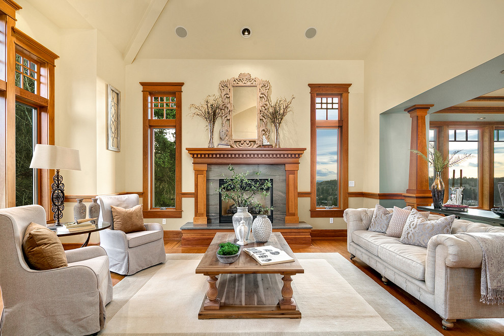 Traditional open concept living room in Seattle with beige walls, medium hardwood floors, a standard fireplace, a stone fireplace surround and brown floor.