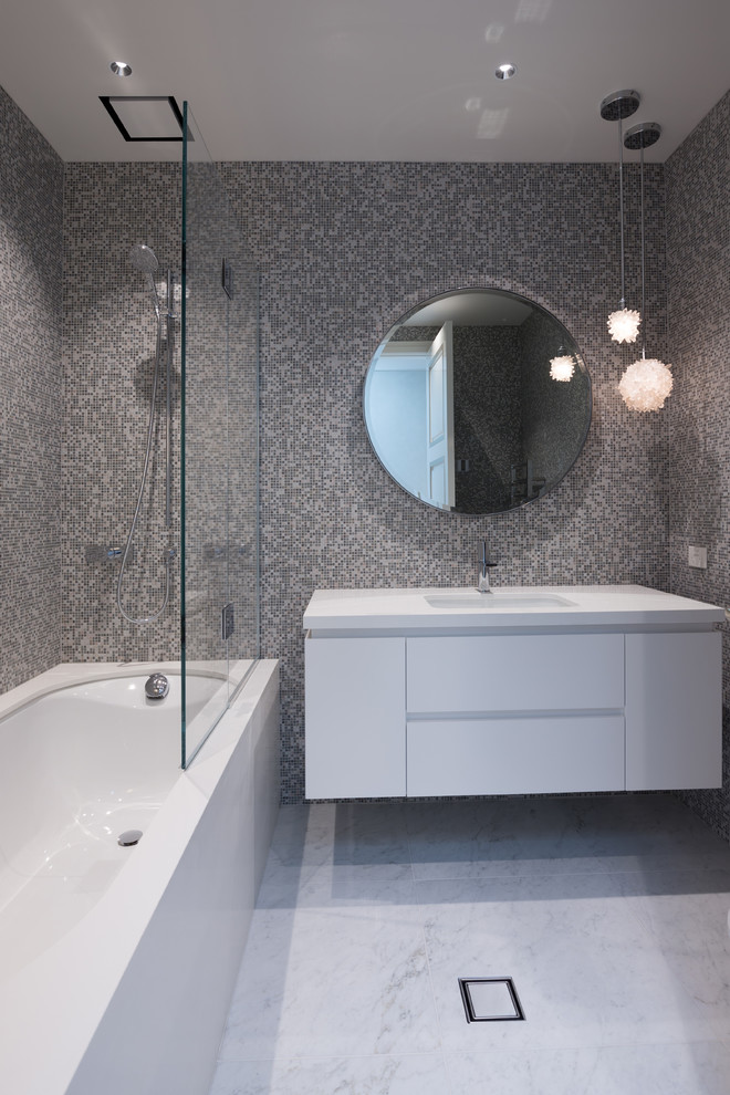 Mid-sized contemporary master bathroom in Auckland with white cabinets, marble benchtops, multi-coloured tile, mosaic tile, white walls and marble floors.