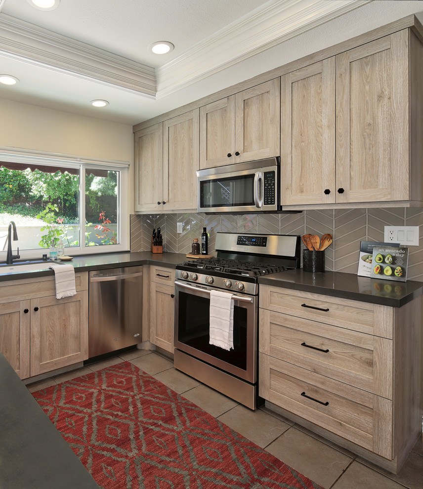 Mid-sized transitional u-shaped kitchen in Orange County with an undermount sink, shaker cabinets, distressed cabinets, quartz benchtops, stainless steel appliances, with island and grey benchtop.