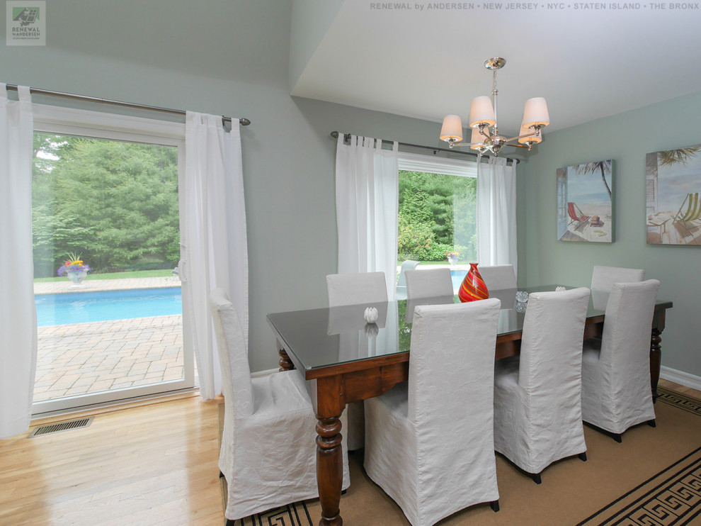 Immagine di una sala da pranzo aperta verso il soggiorno di medie dimensioni con pareti verdi, parquet chiaro, pavimento beige e soffitto a volta