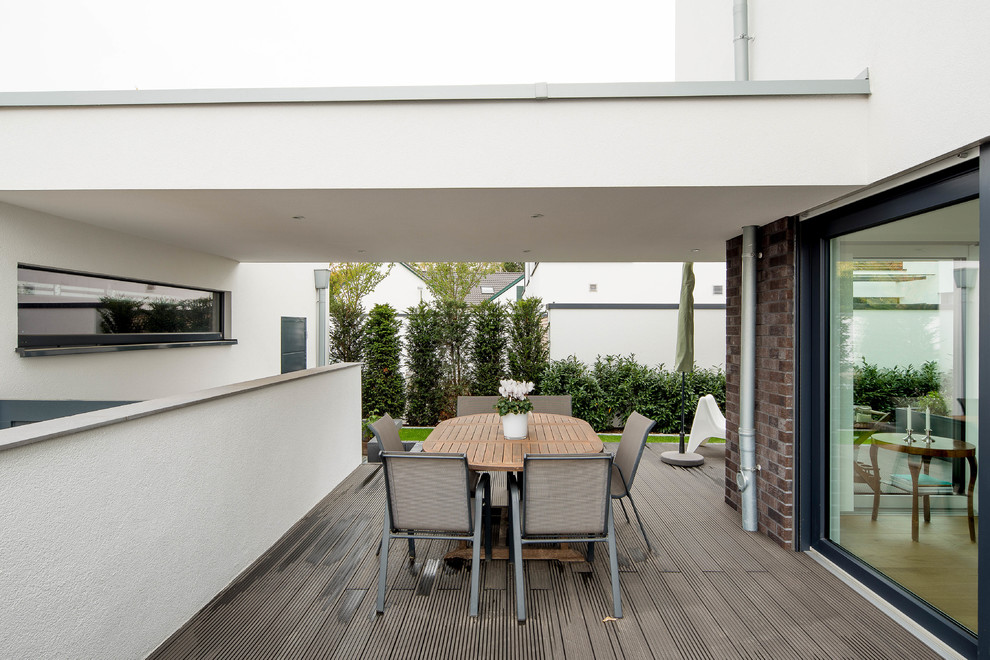 Mittelgroße, Überdachte Moderne Terrasse neben dem Haus mit Feuerstelle in Düsseldorf