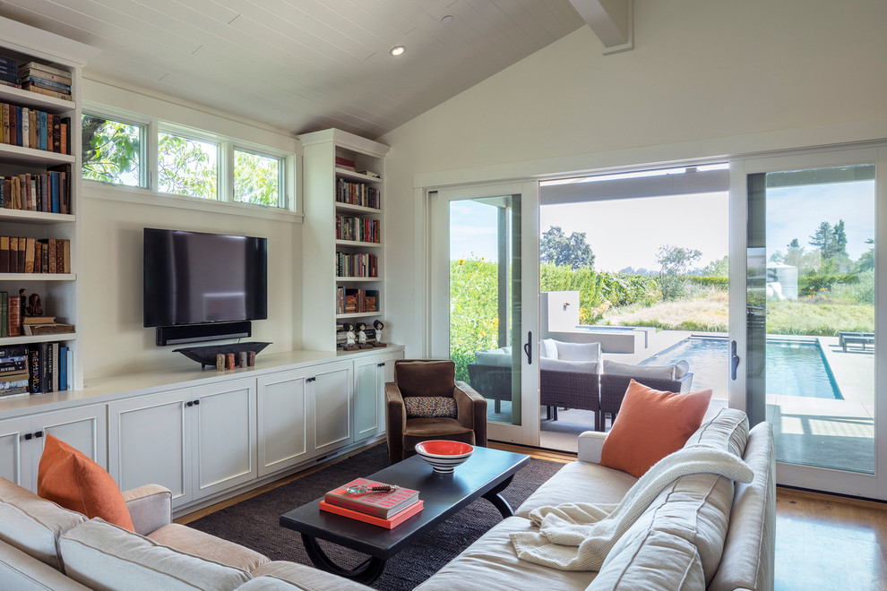 Inspiration for a transitional family room in San Francisco with a library, white walls and a wall-mounted tv.
