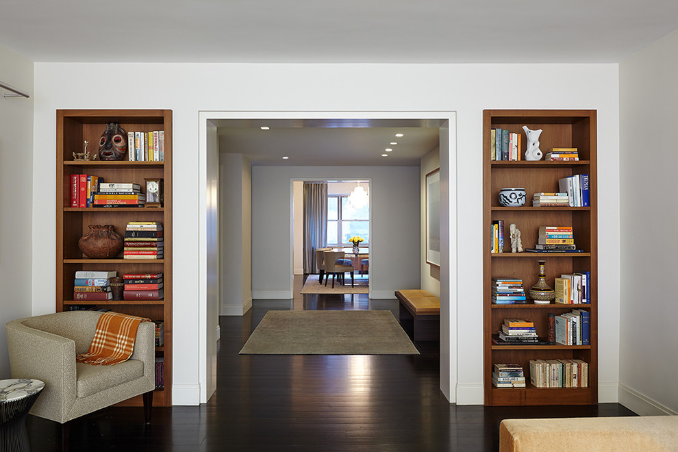 Inspiration for a mid-sized contemporary hallway in New York with white walls, dark hardwood floors and brown floor.