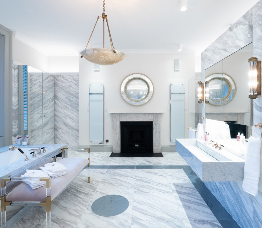 Photo of a large classic ensuite bathroom in London with a freestanding bath, a built-in shower, a wall mounted toilet, grey tiles, marble flooring, a wall-mounted sink, marble worktops, grey floors, a hinged door, grey worktops, a chimney breast and double sinks.